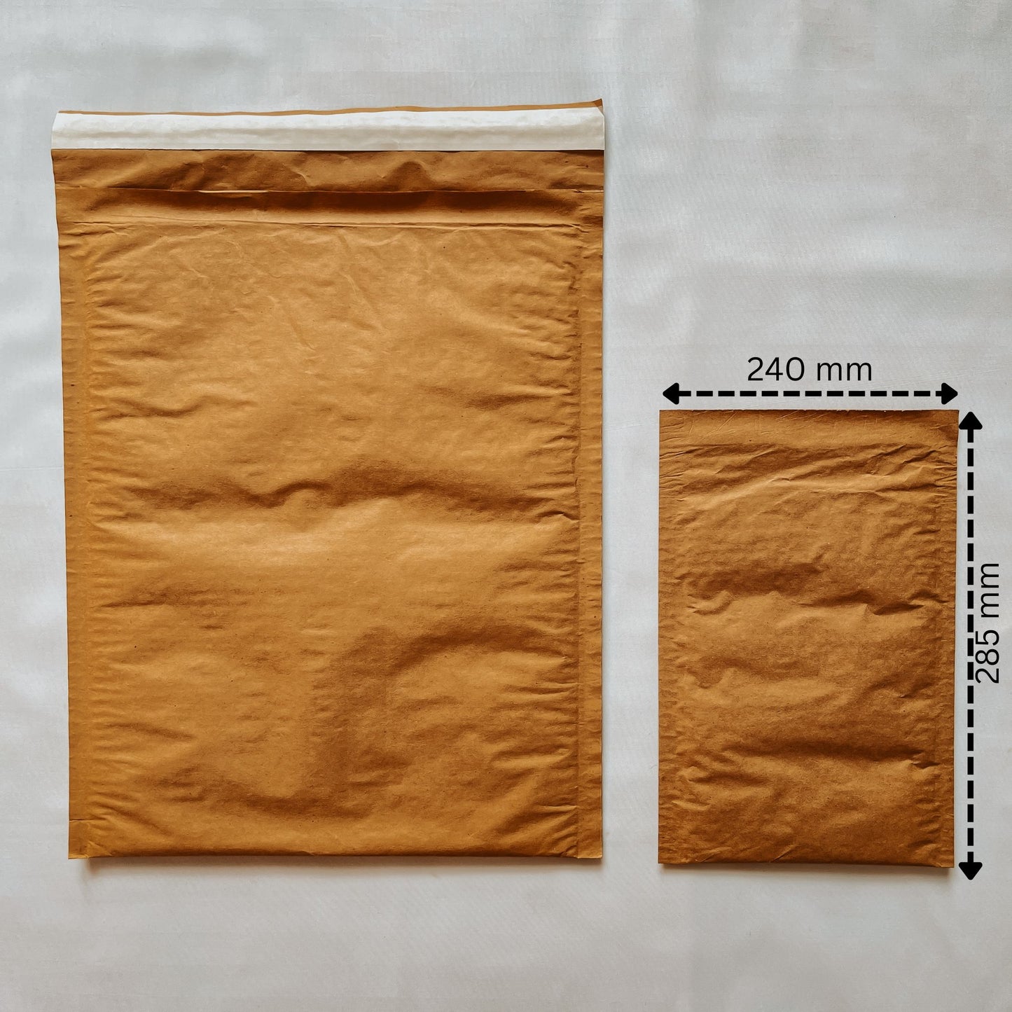 Front view of Jaivik Store EcoArmor shockproof paper mailer (240x285mm) compared to a larger mailer for size reference