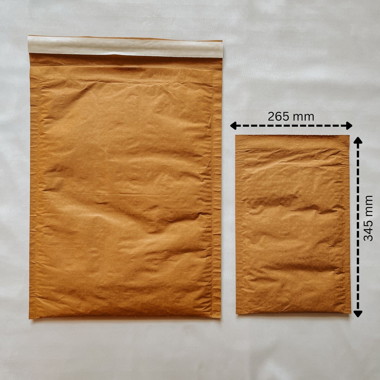 Front view of Jaivik Store EcoArmor shockproof paper mailer (265x345mm) compared to a larger mailer for size reference