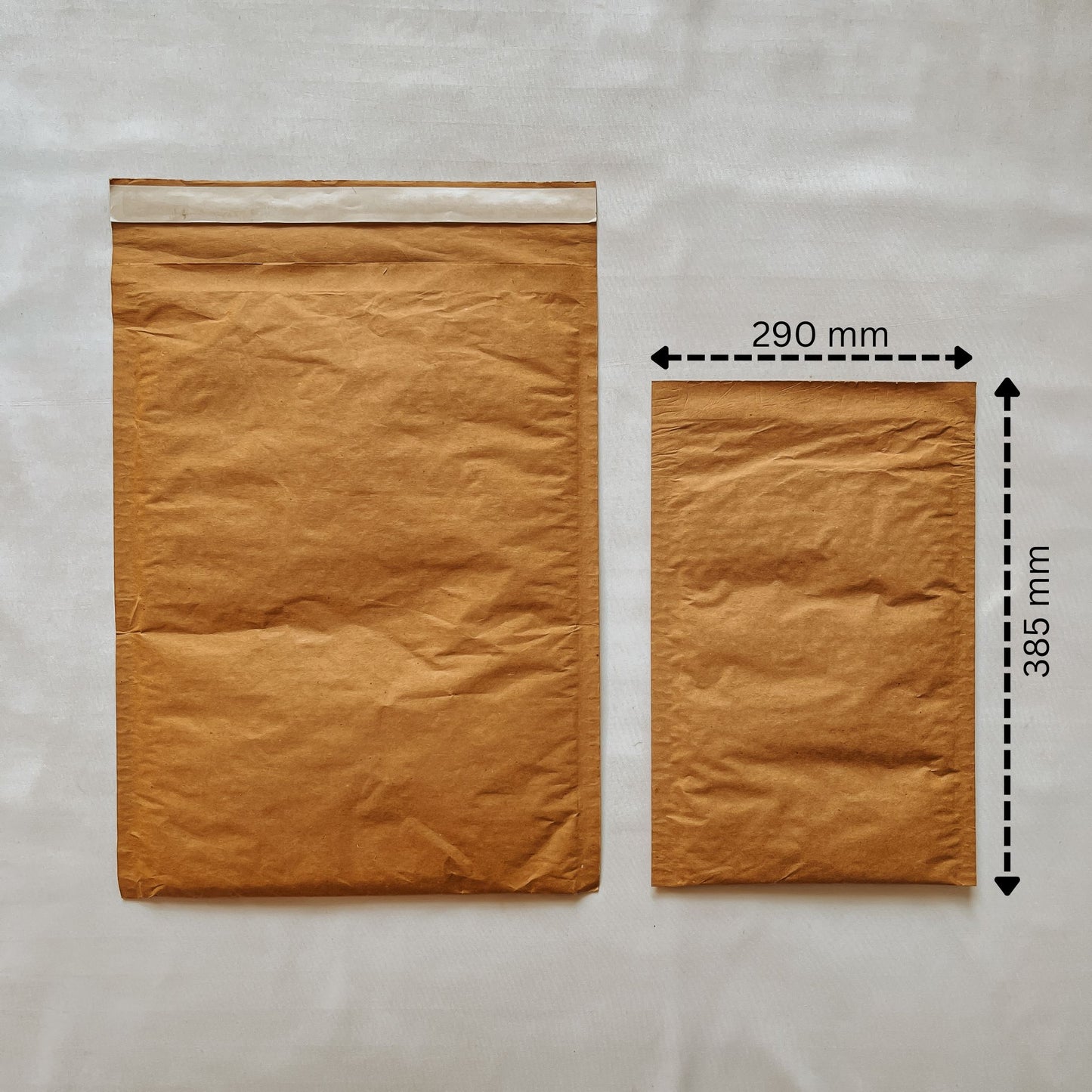 Front view of Jaivik Store EcoArmor shockproof paper mailer (290x385mm) compared to a larger mailer for size reference