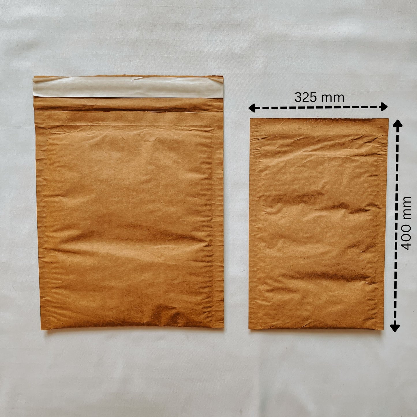 Front view of Jaivik Store EcoArmor shockproof paper mailer (325x400mm) compared to a larger mailer for size reference