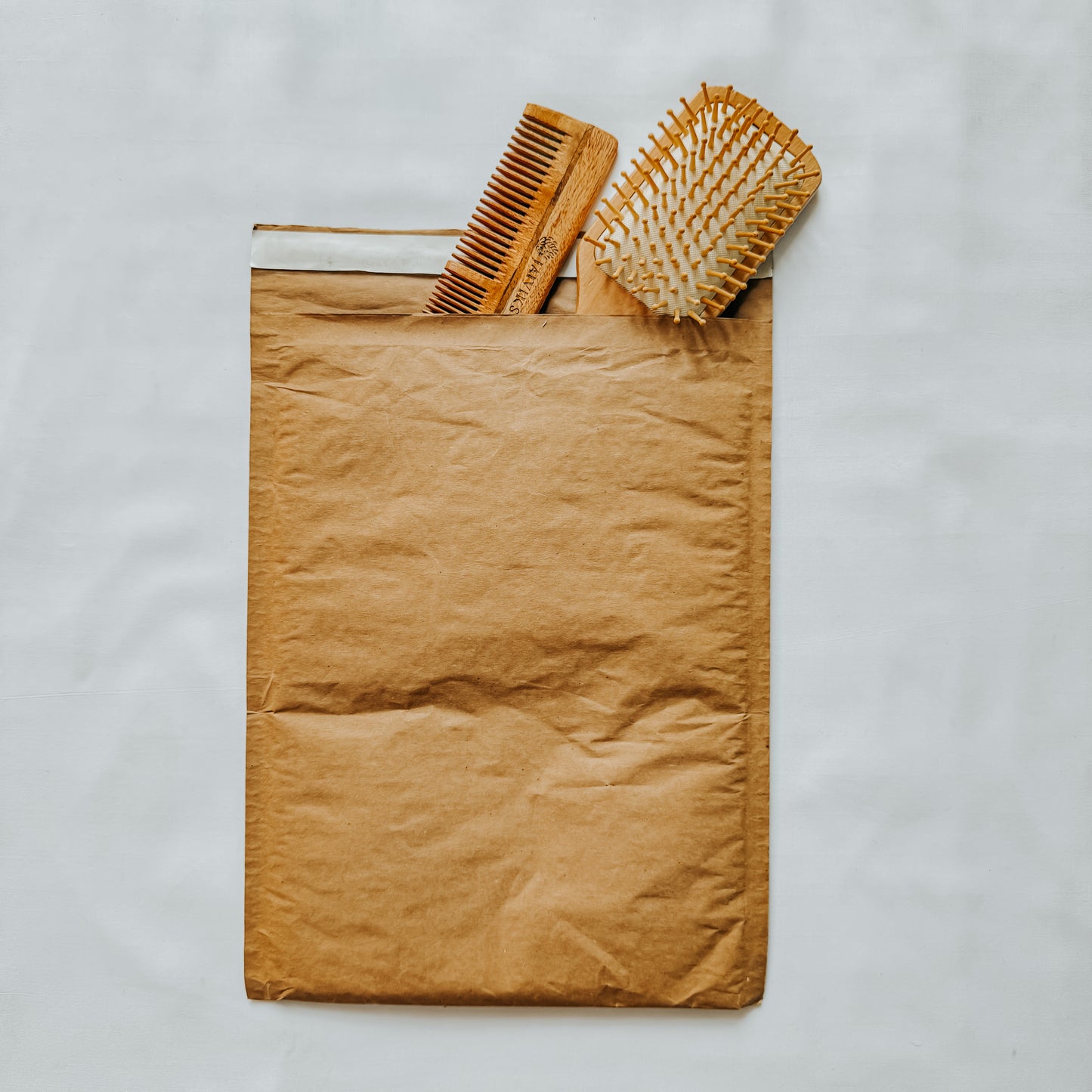 Jaivik Store EcoArmor shockproof paper mailer securely packed with a hairbrush and comb, eco-friendly packaging