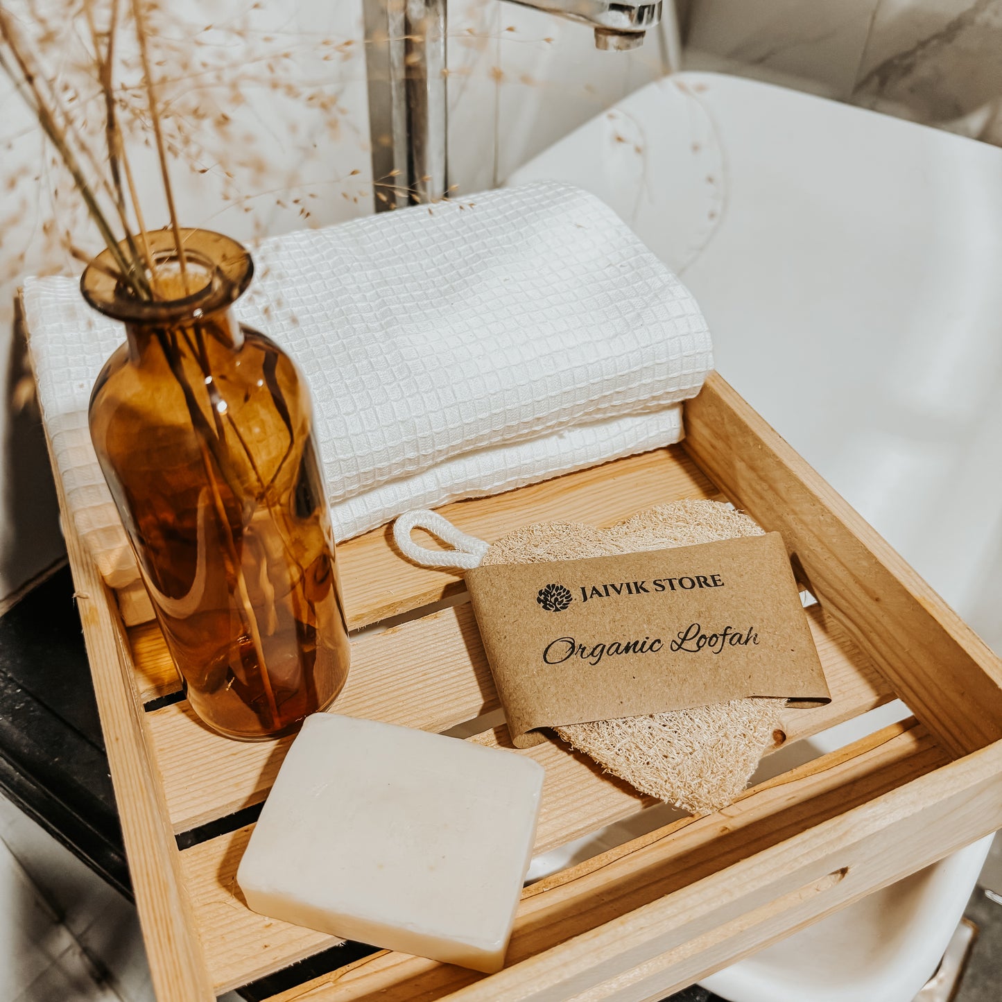 Jaivik Store organic heart-shaped loofah sponge with soap, wooden tray, towel, and dry flowers, emphasizing natural, romantic skincare essentials